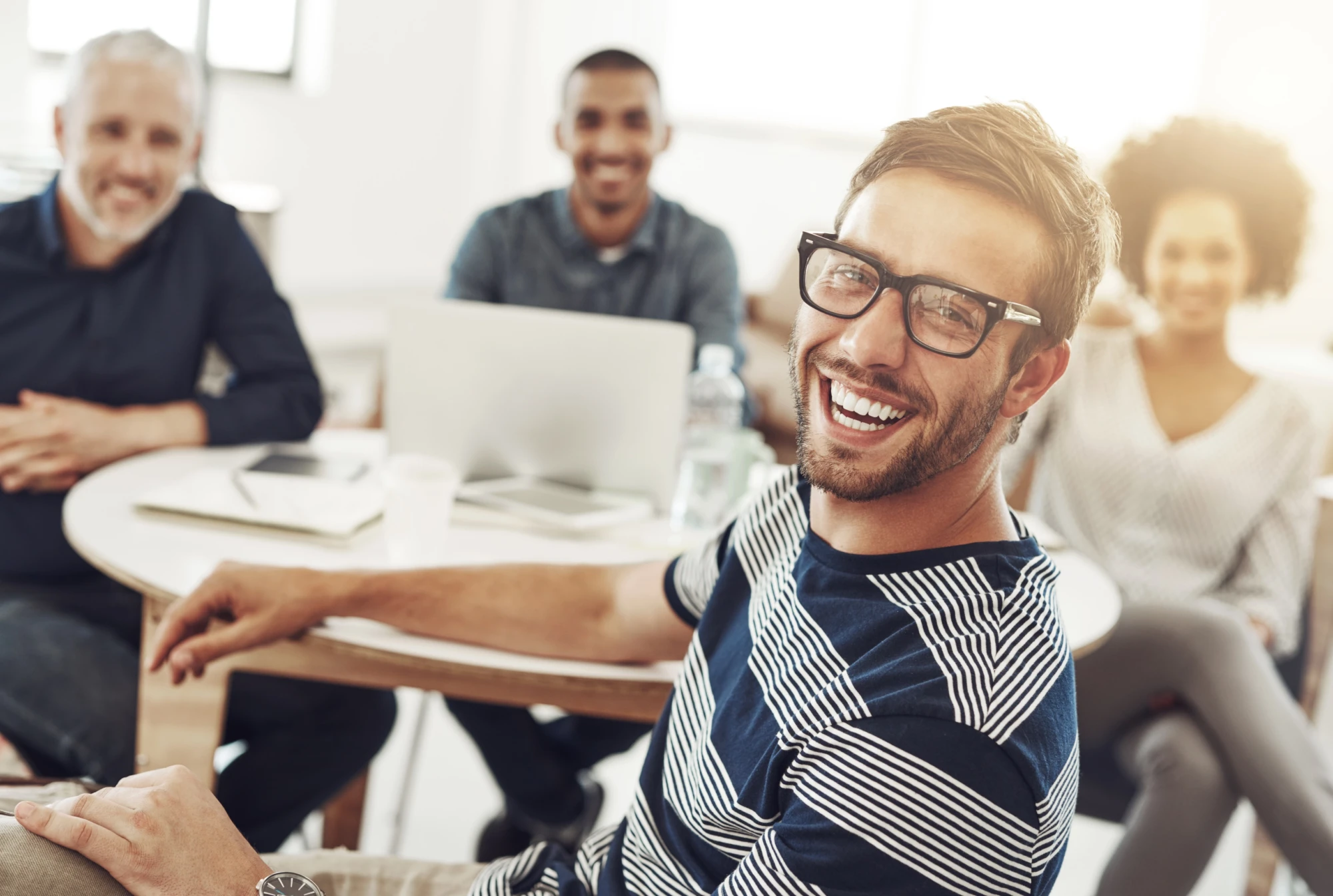 were-focused-doing-our-best-portrait-young-office-worker-sitting-table-with-colleagues-background